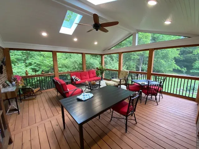 Cedar screen room with a white beadboard ceiling, a skylight, recessed lights, a ceiling fan and red cushioned furniture