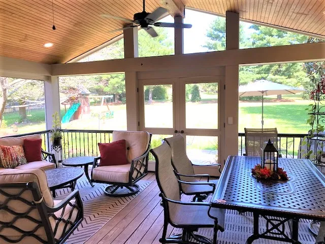Screen room with a vaulted wood ceiling, a dining table and swivel chairs