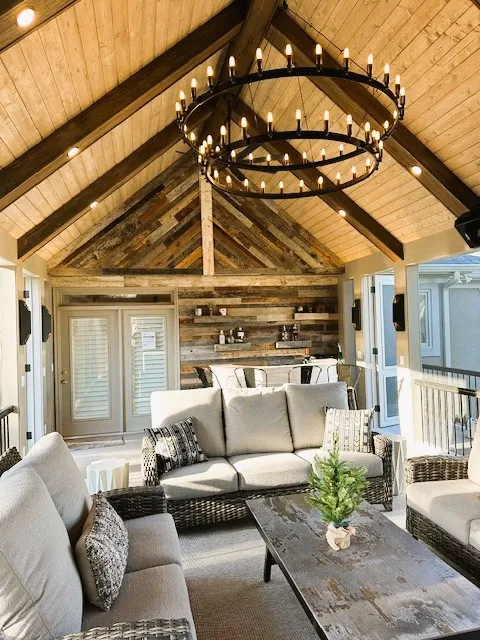 Screen room with a reclaimed wood wall, a vaulted wood ceiling and a round iron chandelier