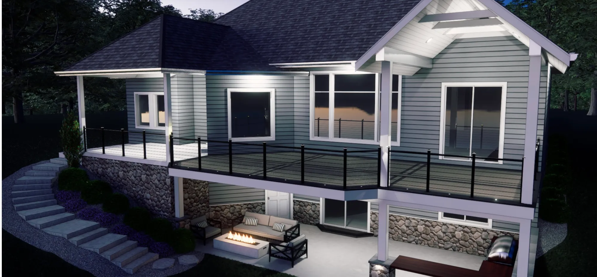 Gray house at dusk with a covered upper porch with black railing over a stone lower level and a fire table on the patio