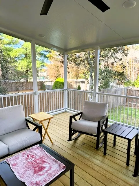 White screen room with a smooth white ceiling, white railing and outdoor chairs on a natural wood floor